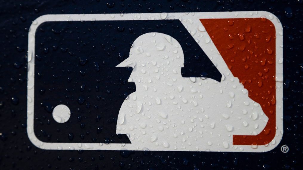 FILE - A rain-covered MLB logo is seen at Fenway Park before Game 1 of the World Series baseball game between the Boston Red Sox and the Los Angeles Dodgers on Oct. 23, 2018, in Boston.  17 former Major League Baseball players who say they were discriminated against because of their age are suing the league, its teams and commissioner Rob Manfred on Wednesday, June 21, 2023.  (AP Photo/Matt Slocum, File)